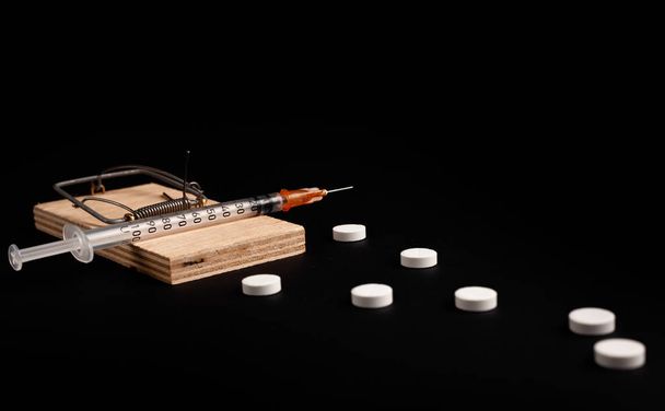 Addiction and dependence on drugs. A stock photo of a mousetrap with a bait in the form of various drugs and medicines. - Photo, Image
