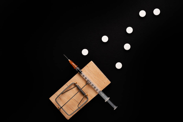 Adicción y dependencia de las drogas. Una foto de archivo de una ratonera con un cebo en forma de varios medicamentos y medicamentos
. - Foto, Imagen