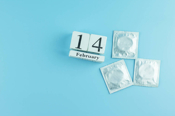 kondomi sinisellä pohjalla. Terveydenhuolto, turvallinen seksi ja rakkaus käsite
 - Valokuva, kuva