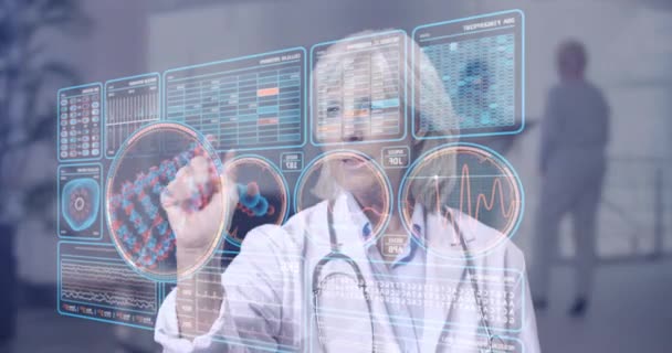Reife Ärztin betrachtet futuristische medizinische Diagramme in einem High-Tech-Krankenhaus - Filmmaterial, Video