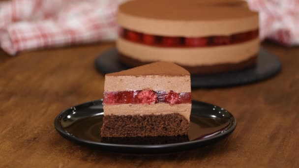 Pedazo de delicioso pastel de mousse de chocolate con jalea de frambuesas
. - Metraje, vídeo