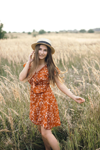 Girl in a red dress on a wheat field - 写真・画像