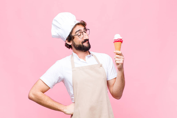 young crazy chef man with an ice cream against pink wall - Fotoğraf, Görsel
