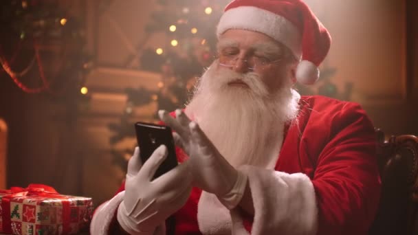 Santa Claus uses a smartphone and Internet applications. - Video, Çekim