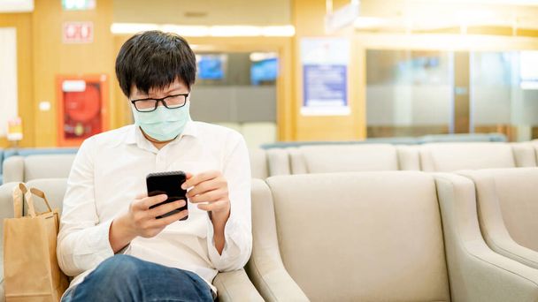Paziente di sesso maschile che utilizza smartphone in ospedale
 - Foto, immagini