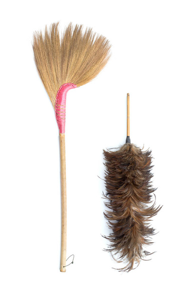Vassoura de grama marrom e espanador de penas isolado no backgroun branco
 - Foto, Imagem