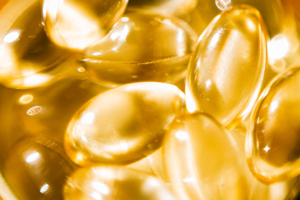 Macro shot of fish oil vitamin d transparent capsules. Dietary supplements. - Fotoğraf, Görsel