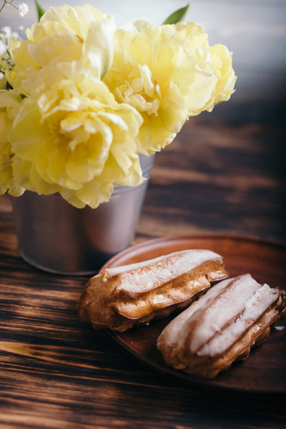 Choux cake on a wooden background with tulips - Photo, Image