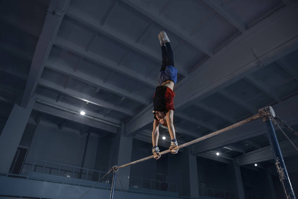 Little male gymnast training in gym, flexible and active - Valokuva, kuva