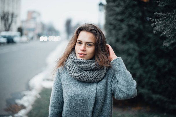 Girl in a gray coat in the winter in the city - Foto, Bild