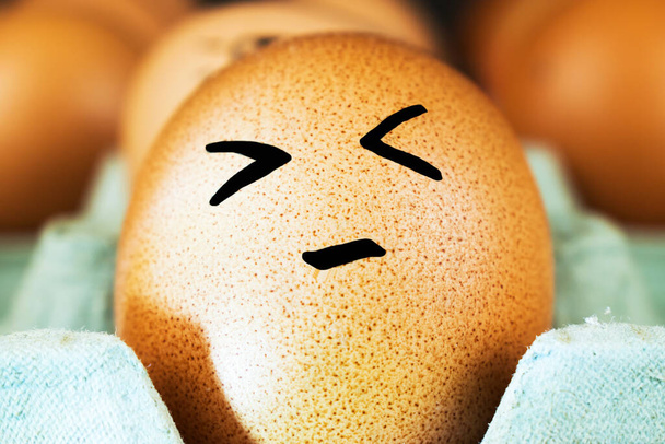 Uova di pollo emotive in un vassoio. Interessante smorfia sulle uova
.  - Foto, immagini