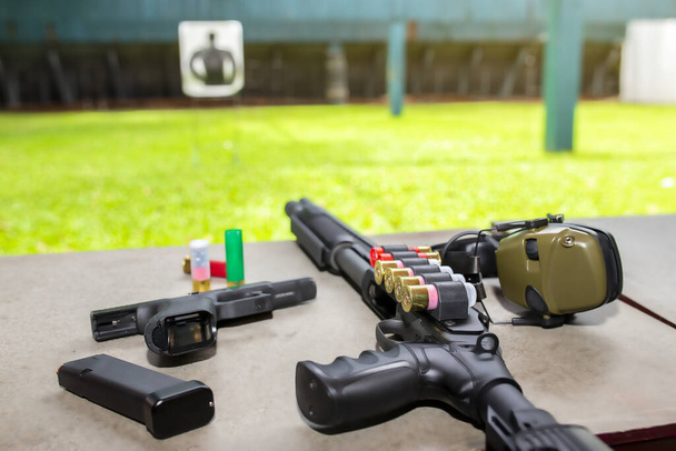 Egy hosszú puska lőszerrel az asztalon. 9 mm-es pisztoly és golyó a védelemhez. - Fotó, kép