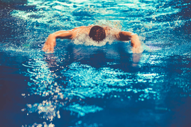 Férfi úszó a medencénél. Víz alatti fotó. Férfi úszó. - Fotó, kép