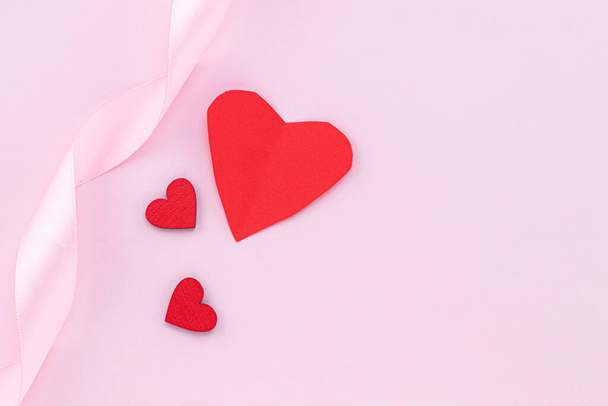 Valentines Day background. Red hearts on pastel pink background. - Фото, изображение