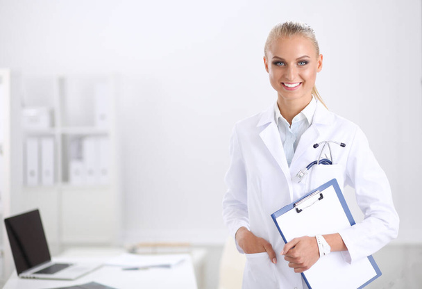 Una doctora sonriente con una carpeta de uniforme en el hospital. Médico sonriente - Foto, Imagen