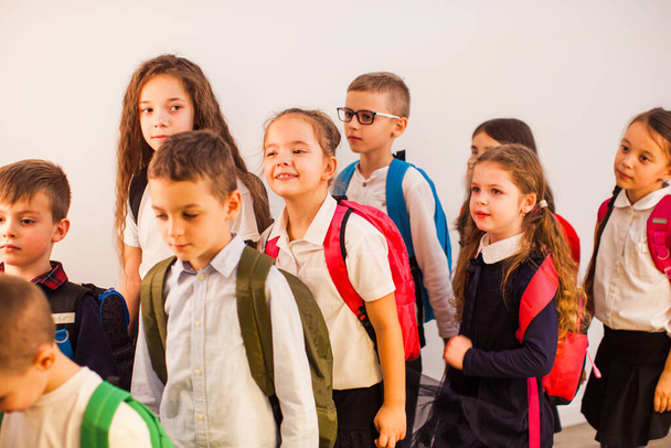 Glückliche Schulkinder sind bereit für Bildung. Schulkinder in Uniform mit Rucksäcken zum Unterricht - Foto, Bild