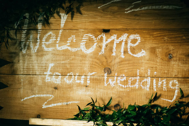 Willkommen - Einladung für Gäste auf einer Holztafel im Restaurant. - Foto, Bild