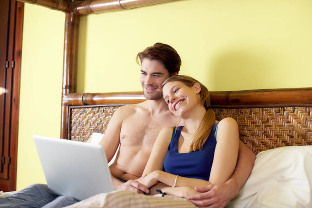 young couple lying on bed with pc - Photo, image