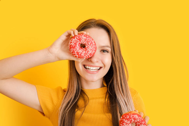 Funny young woman with tasty donuts on color background - Photo, Image
