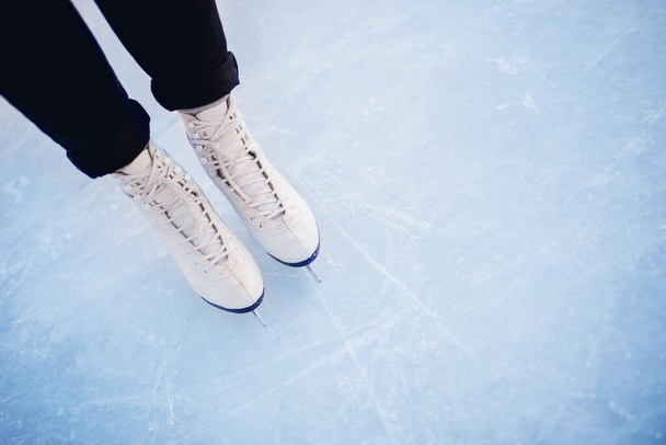 Femme debout sur la glace en patins à glace blanche, flocons de neige coucher de soleil. Vue du dessus
 - Photo, image