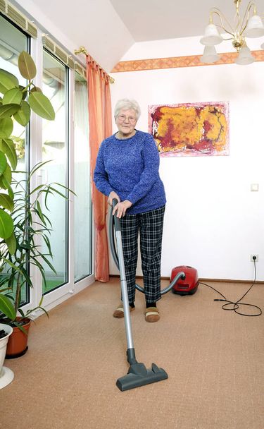 senior with vacuum cleaner - Zdjęcie, obraz