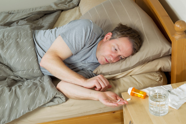 Зрілий чоловік кладе ліки таблетки в руку
 - Фото, зображення
