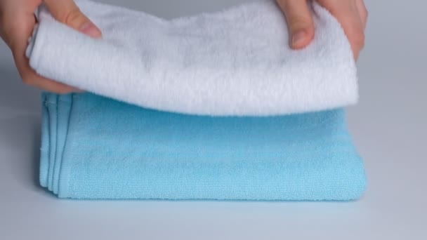 Close-up van de handen zetten stapel verse badhanddoeken op het laken. Roomservice schoonmaakster hotelkamer macro - Video