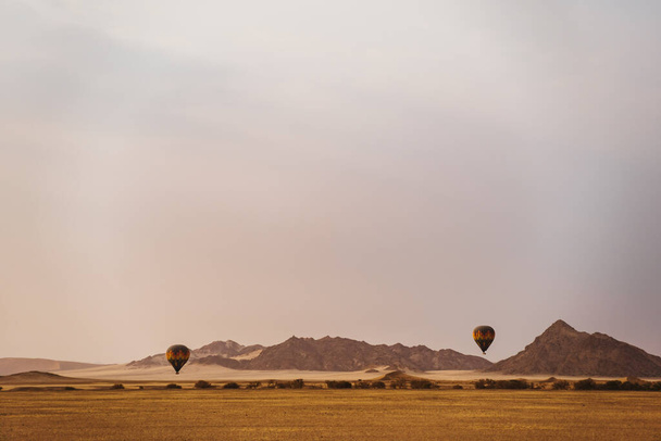 Hot air balloons flying in morning at desert - Fotoğraf, Görsel