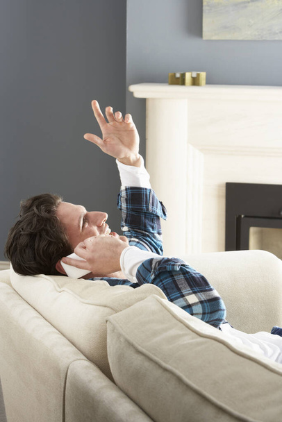 Man Relaxing Sitting On Sofa At Home Talking On Phone - Фото, зображення