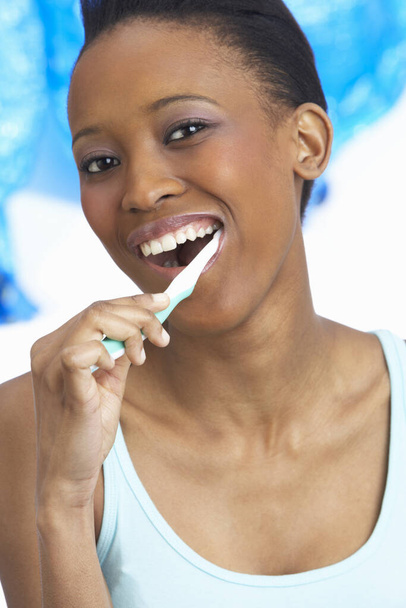 Young Woman Brushing Teeth In Studio - Фото, изображение