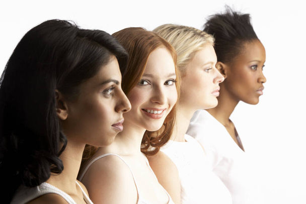 Portrait Of Four Attractive Young Women In Studio Standing In Line - Фото, изображение