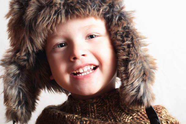 毛皮の帽子の面白い笑顔子供。ファッション子供。冬のスタイル。小さな男の子。子供 - 写真・画像
