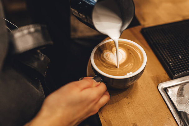 バリスタはコーヒーショップでカプチーノを作る - 写真・画像