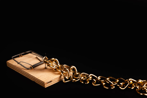 Gold chain in a mousetrap. Concept photo of a bait for greedy. Protection of values. - Photo, Image