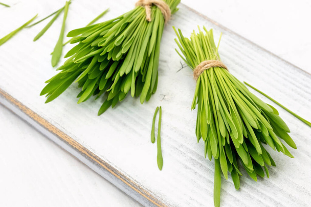 Fresh barley grass on a white wooden table - Photo, Image