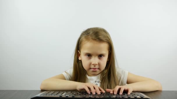 Een ongeduldig meisje drukt op de toetsenbordknoppen - Video