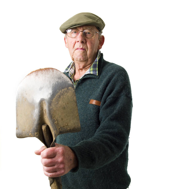 Senior man standing with shovel - Photo, image