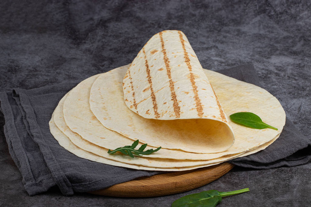 Stapel von Mais-Tortillas auf dunklem Hintergrund. Mexikanisches Essen - Foto, Bild