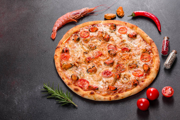 Tasty sliced pizza with seafood and tomato on a concrete background - Photo, Image