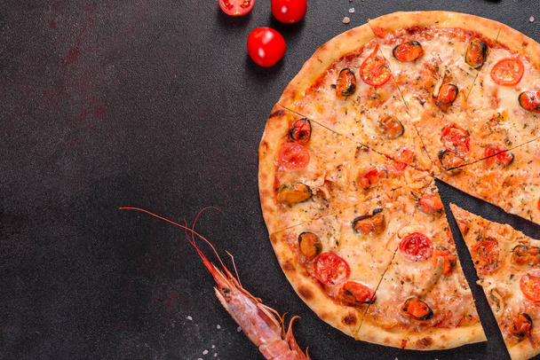 Вкусная нарезанная пицца с морепродуктами и помидорами на бетонном фоне
 - Фото, изображение