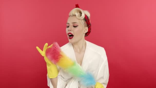 Smiling pin up woman in rubber gloves holding duster - Footage, Video