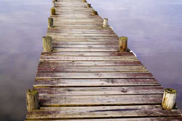 houten detail achtergrond ponton op water meer met spiegel beeld van de hemel - Foto, afbeelding