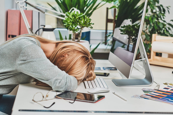 La mujer está cansada mientras trabaja en la oficina
 - Foto, Imagen