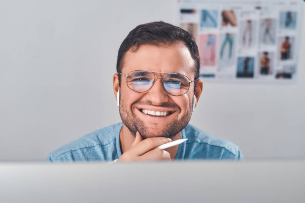 Портрет человека в очках с ручкой в руке
 - Фото, изображение