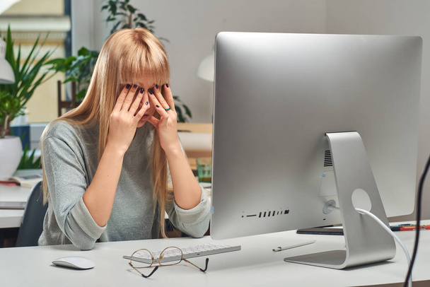 Vrouw voelt zich moe tijdens het werken in het kantoor - Foto, afbeelding