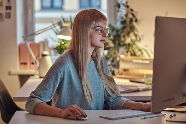 Ελκυστική γυναίκα εργάζεται στον υπολογιστή - Φωτογραφία, εικόνα
