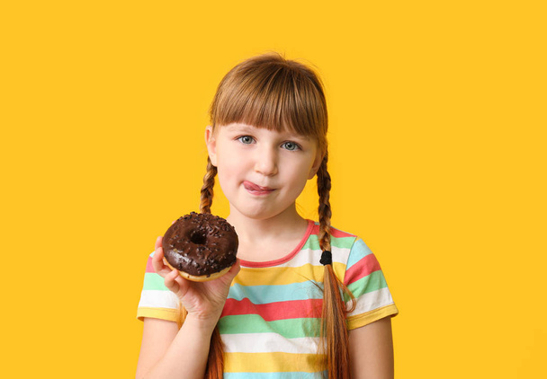 Funny little girl with donut on color background - 写真・画像