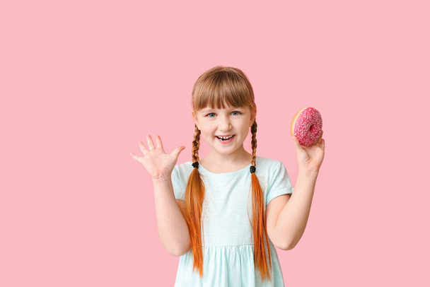 Αστείο κοριτσάκι με ντόνατ στο φόντο χρώμα - Φωτογραφία, εικόνα