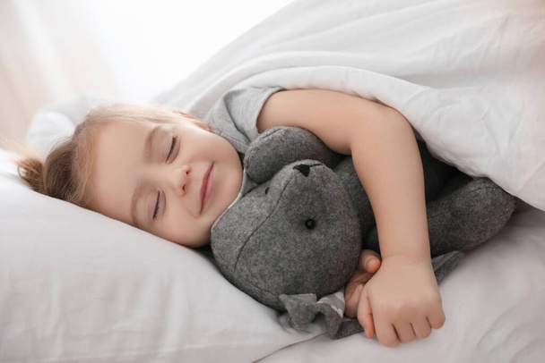 Cute little girl sleeping with toy bunny at home. Bedtime schedule - Photo, Image