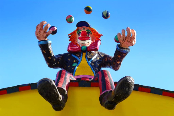 clown juggles while sitting on the roof with balls - Fotografie, Obrázek